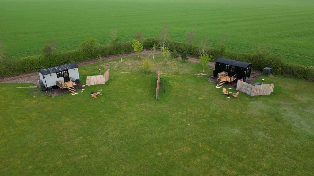 Aerial view of the two shepherd huts in their meadow